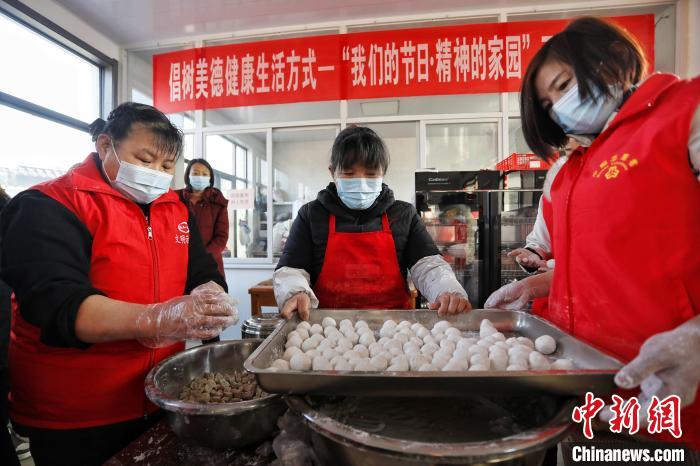 在泰安市泰山區(qū)邱家店鎮(zhèn)王林坡村的幸福食堂，眾多志愿者帶領(lǐng)村里的庫區(qū)移民包元宵?！￡愱?攝