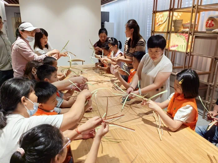 山東手造展示體驗(yàn)中心，博興草編傳承人張慧華帶孩子們體驗(yàn)草編技藝